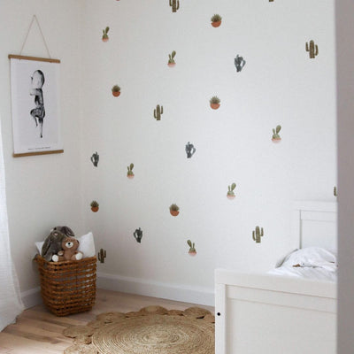 Bedroom with fabric wall decals featuring a variety of cacti and plants, showcasing vibrant colours that bring a touch of nature indoors. 