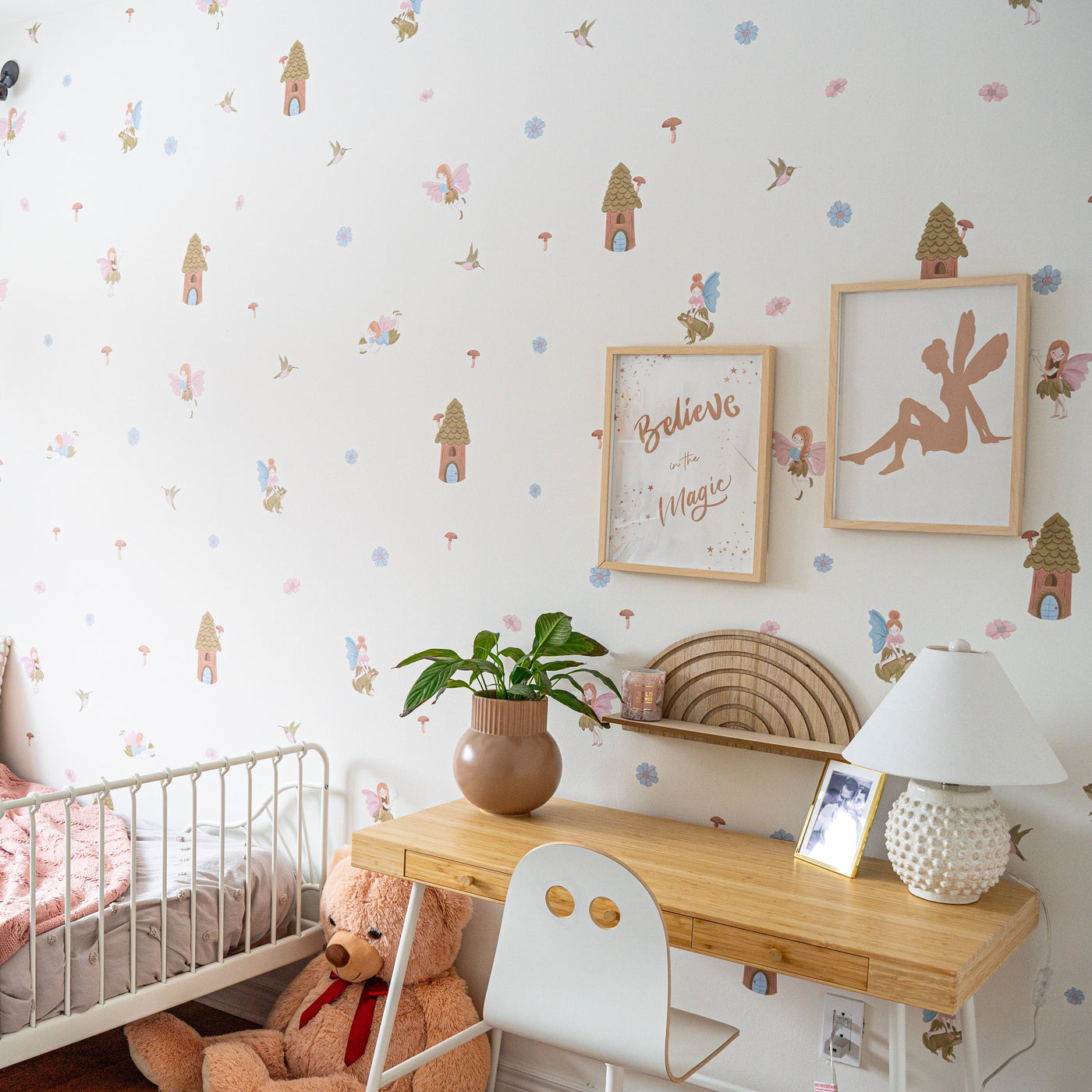 A whimsical little girls bedroom featuring colourful fairy wall decals surrounded by soft flowers, charming mushrooms, and enchanting fairy houses, creating a magical atmosphere. 