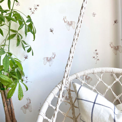 Neutral fabric wall decals featuring cute llamas and fluffy cotton balls in a child's room, perfect for adding a whimsical touch to any space.