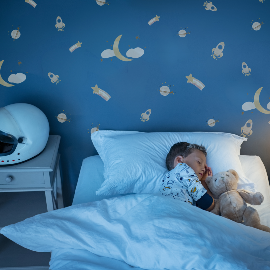 Fabric wall decals featuring neutral space-themed designs, including stars, planets, and rockets in a child's bedroom. 