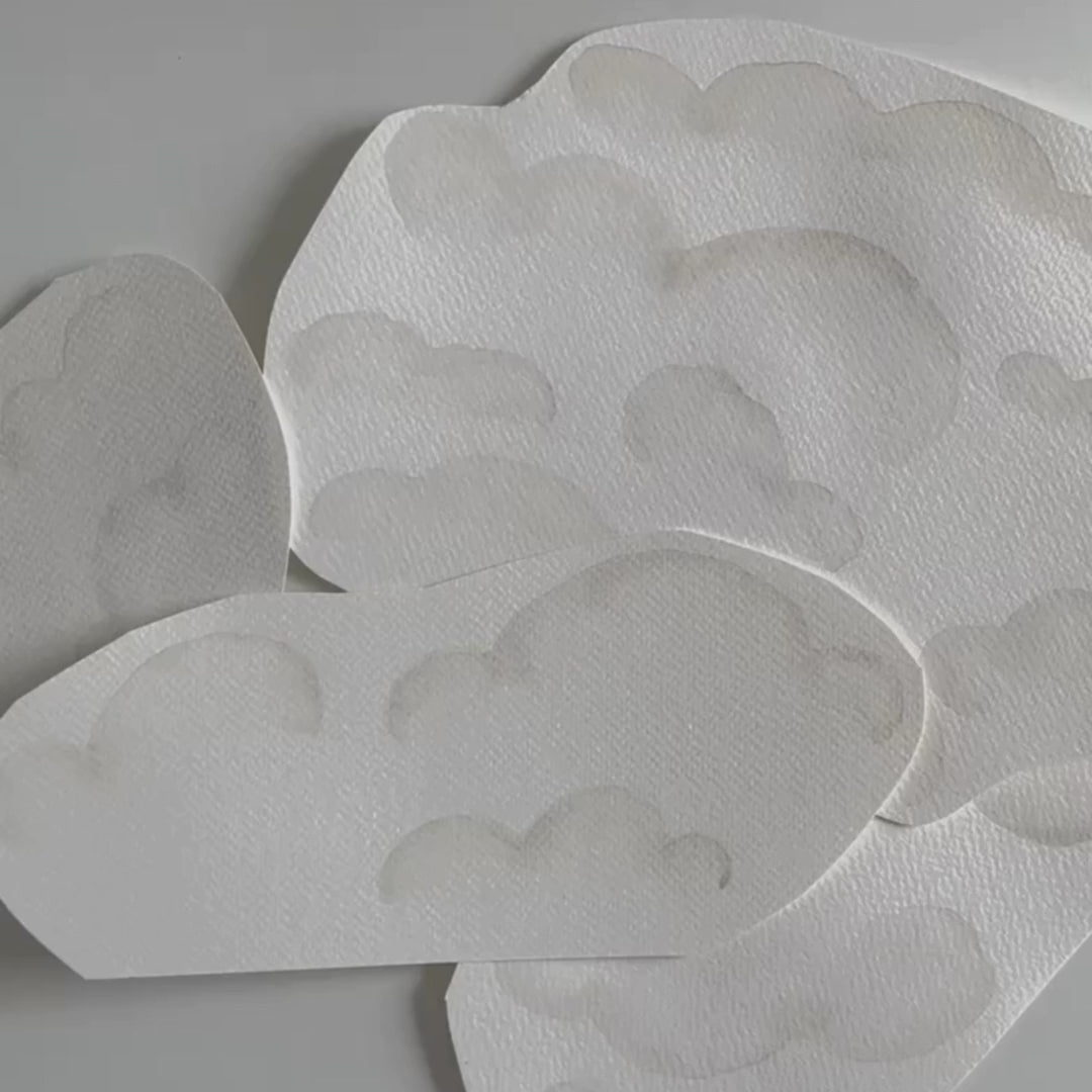 Video of Sabina the artist skillfully creating the cloud fabric wall decals, showcasing the artistic process from sketching to application, providing insight into the design and crafting techniques.