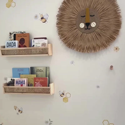 A video of vibrant fabric wall decals in a playroom showcasing a delightful arrangement of bees, hexagons, leaves, flowers, and daisies, creating a cheerful and nature-inspired decor for a child's room or play area. 