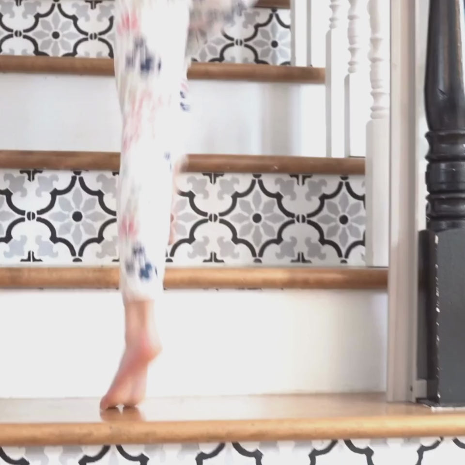 A little girl running up the stairs to see her whimsical bedroom featuring colourful fairy wall decals surrounded by soft flowers, charming mushrooms, and enchanting fairy houses, creating a magical atmosphere. 