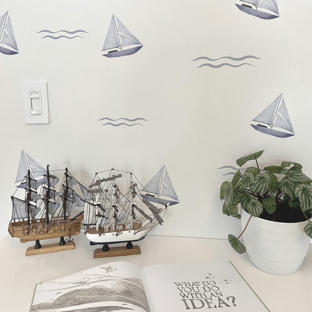 Charming blue sailboats surrounded by waves, on a dresser depicted as fabric wall decals, perfect for adding a nautical theme to children's rooms or play areas.