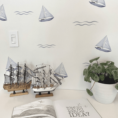 Charming blue sailboats surrounded by waves, on a dresser depicted as fabric wall decals, perfect for adding a nautical theme to children's rooms or play areas.