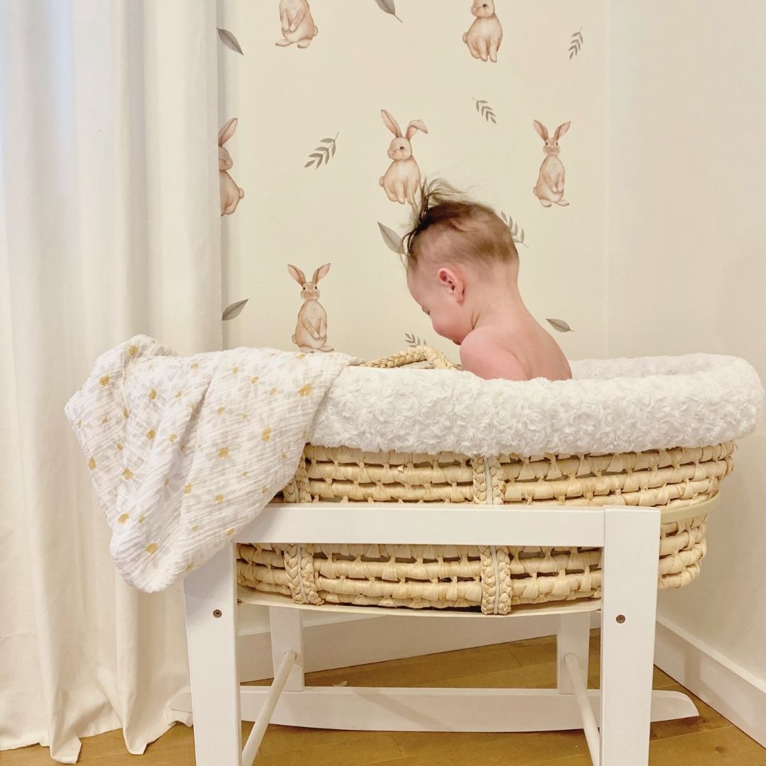 Soft fabric wall decals featuring playful bunnies surrounded by various leaves, creating a whimsical and nature-inspired decor in a babies nursery. 