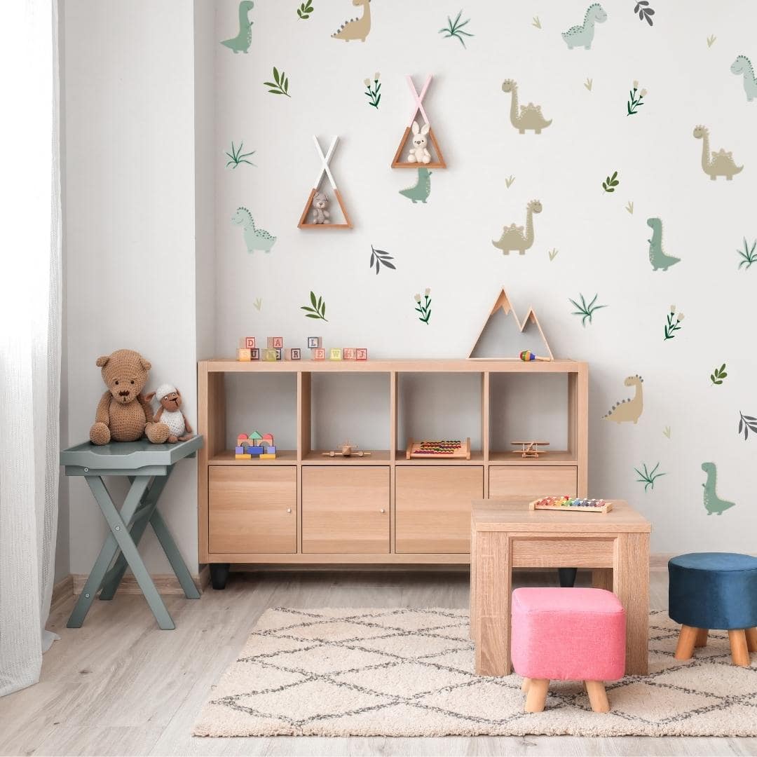 Colourful fabric wall decals in a play room featuring playful dinosaurs surrounded by lush leaves and vibrant flowers, designed with non-toxic materials, perfect for creating a fun and safe environment in a child's room or play area.