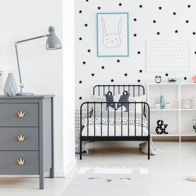 Peel and stick mini star fabric wall decals in a bedroom, ideal for decorating walls with a playful and cheerful theme.
