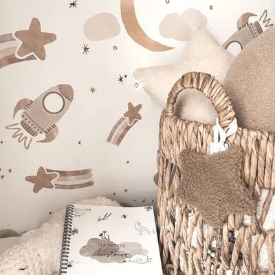 Fabric wall decals featuring neutral space-themed designs, including stars, planets, and rockets, perfect for adding a whimsical touch to a child's bedroom or nursery.