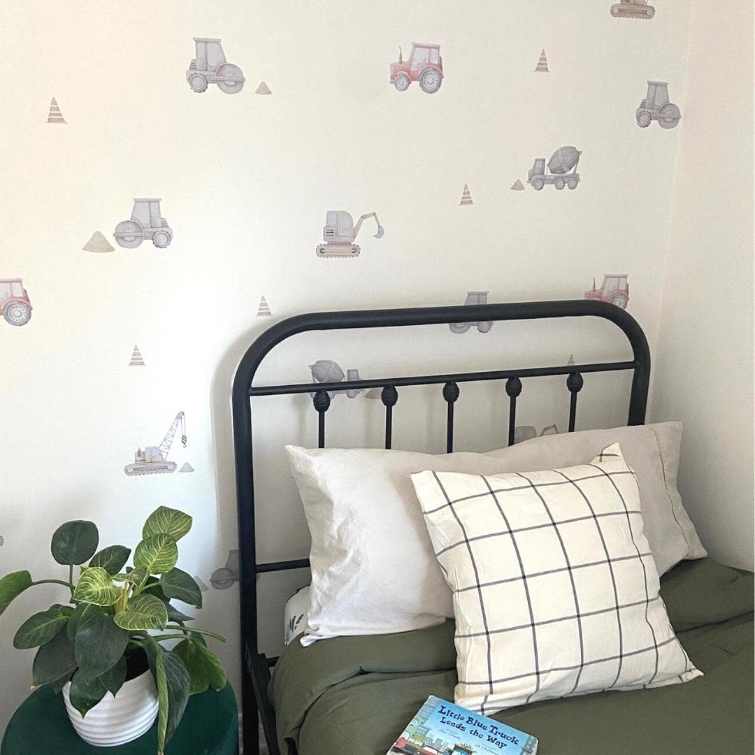 Fabric wall decals in a little boys room showcasing various construction trucks, including diggers, dump trucks, and cranes, ideal for decorating a child's room or play area with a construction theme