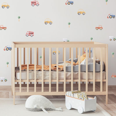 Colourful fabric wall decals in a nursery featuring various designs of cars and trucks, perfect for decorating a child's room or play area