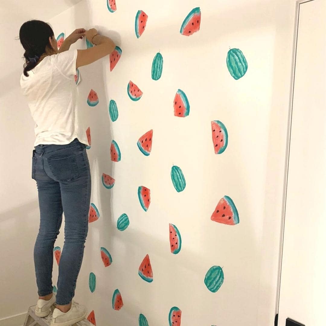 Picture of a woman applying watermelon wall decals